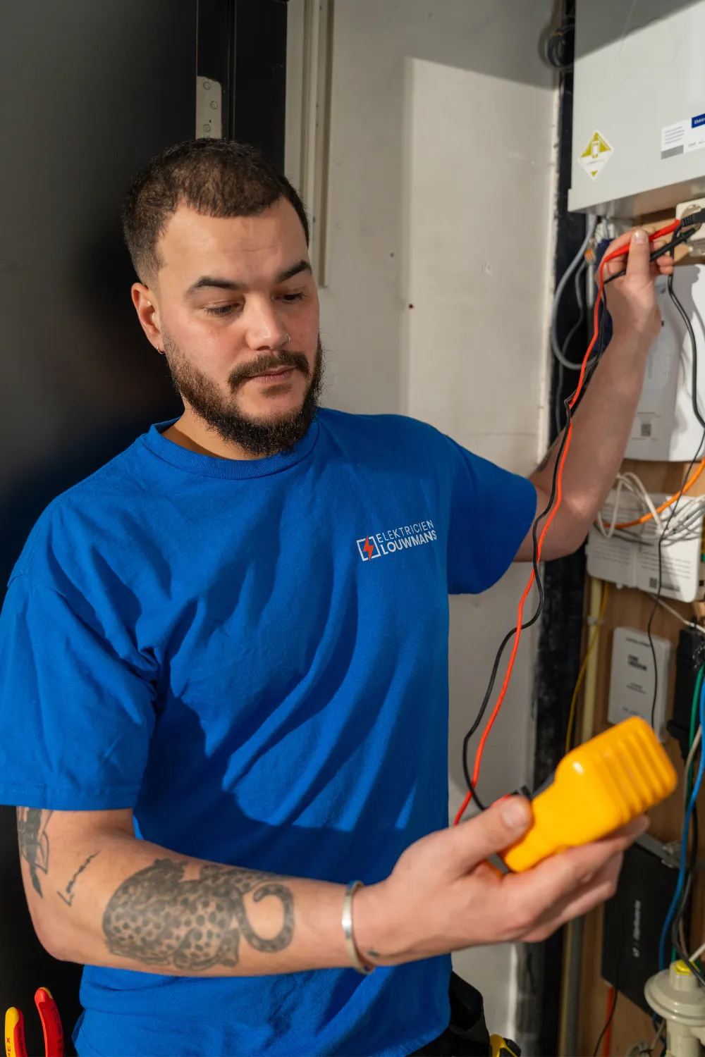 Elektricien van Louwmans test met een meetinstrument in de meterkast