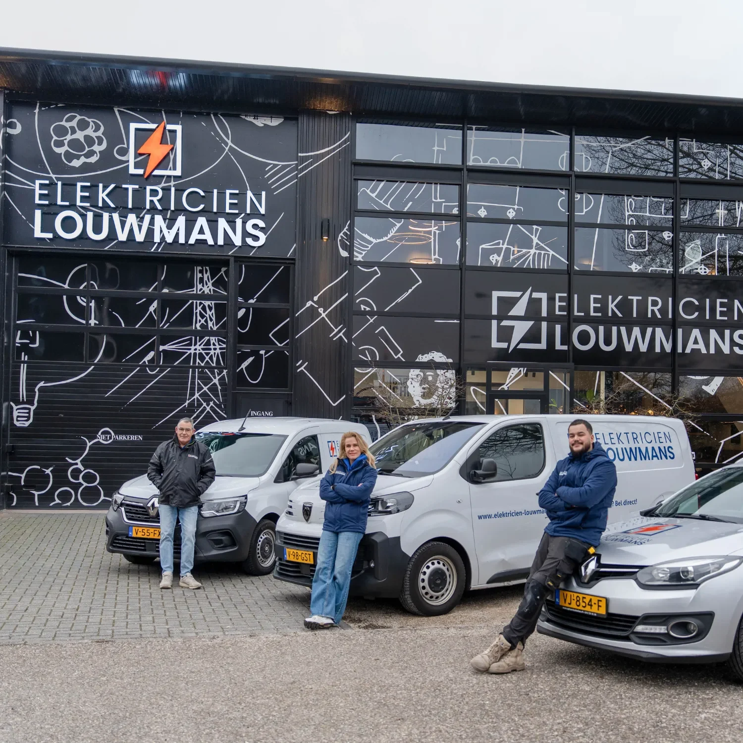 Medewerkers van Elektricien Louwmans bij het bedrijfspand en de bedrijfsbussen