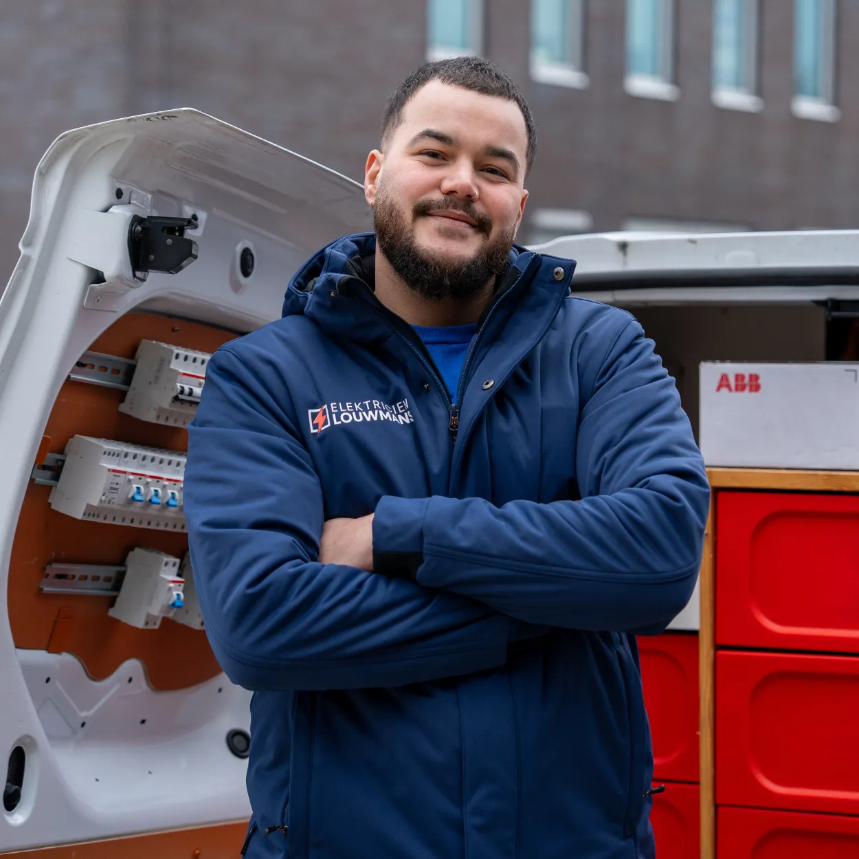 Elektricien van Louwmans bij de geopende bedrijfsbus met groepenkastmateriaal